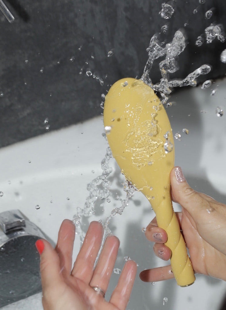 Eau et brosse à cheveux jaune