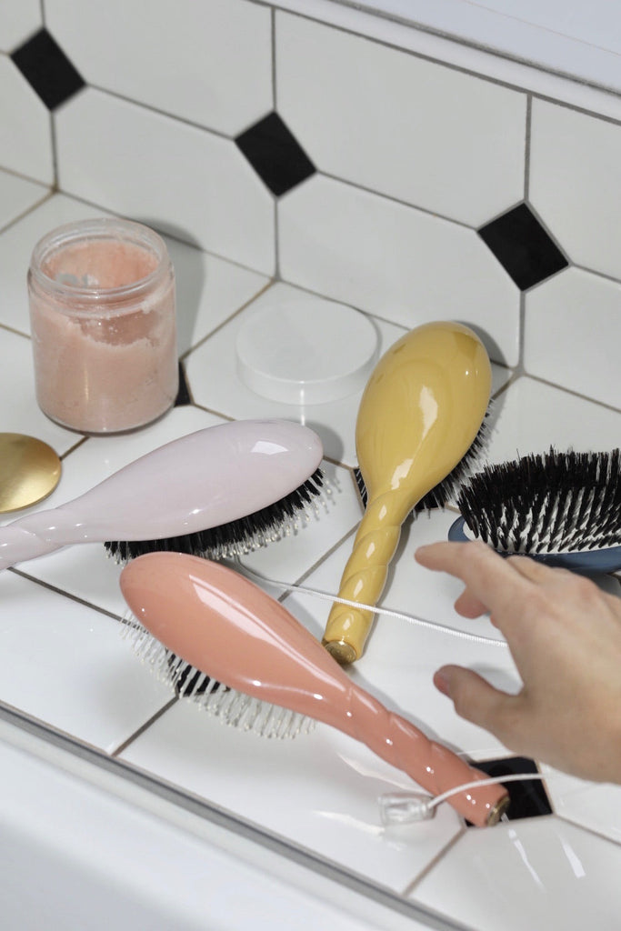 Brosses jaune et corail dans salle de bain